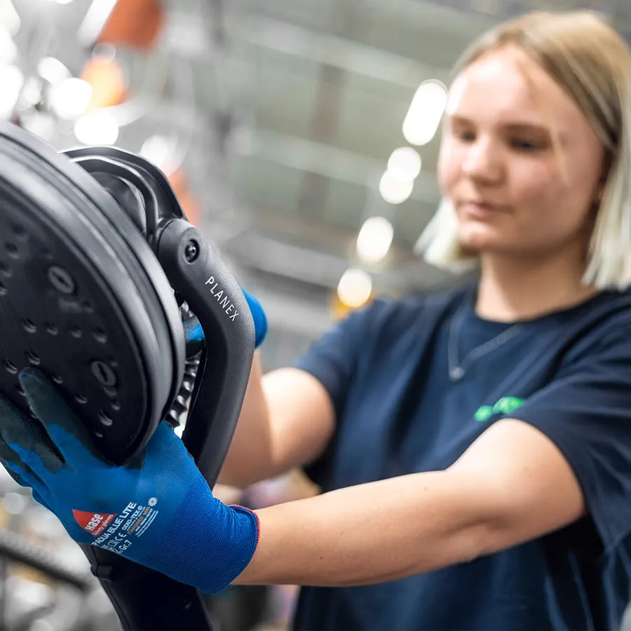 In the spacious plant, employees assemble power tools at modern workstations.