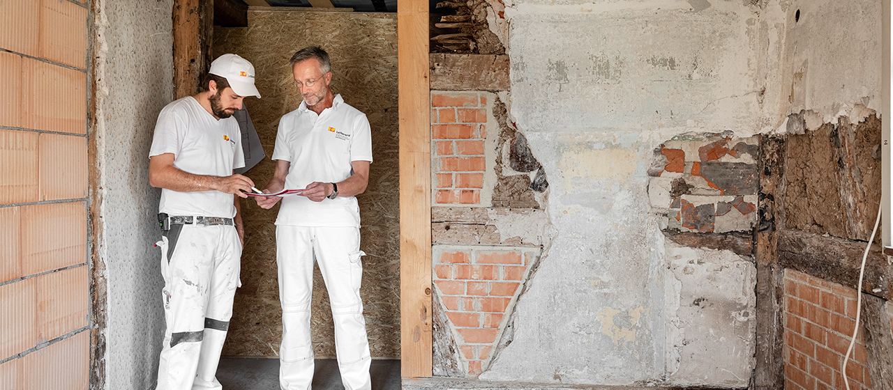 Malermeister und Restaurator Manfred Schuler und Mitarbeiter Marco Dworzak besprechen die  weiteren Schritte der Sanierung