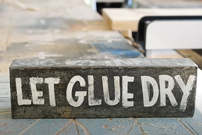 Ein Schild mit der Aufschrift Let Glue Dry.