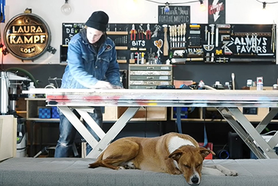 Die Makerin Laura Kampf bei der Arbeit in ihrer Werkstatt mit ihrem Hund Smudo.
