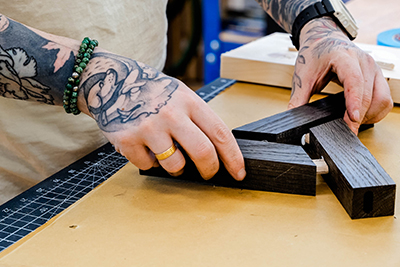 Tischlermeister Jonas Winkler setzt die zugeschnittenen Holzleisten zu einem Muster zusammen