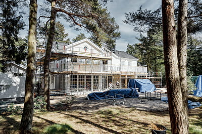 Blick auf das eingerüstete Holzhaus in den schwedischen Wäldern