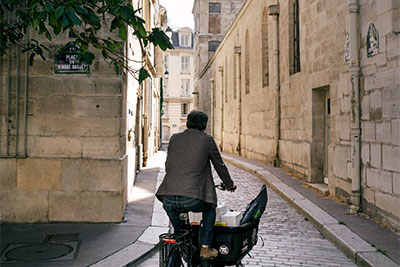 Philippe Genty setzt sich auf sein Fahrrad, winkt freundlich und fährt zu seinem nächsten Kunden.