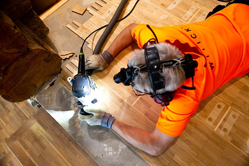Der finnische Parkettleger bearbeitet den Holzboden mit der Festool Oberfräse