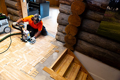 Der finnische Parkettleger bearbeitet mit dem Boden mit der Festool Oberfräse